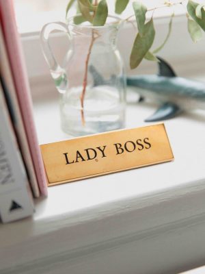 Vase transparent avec feuillage léger et étiquette Lady Boss devant